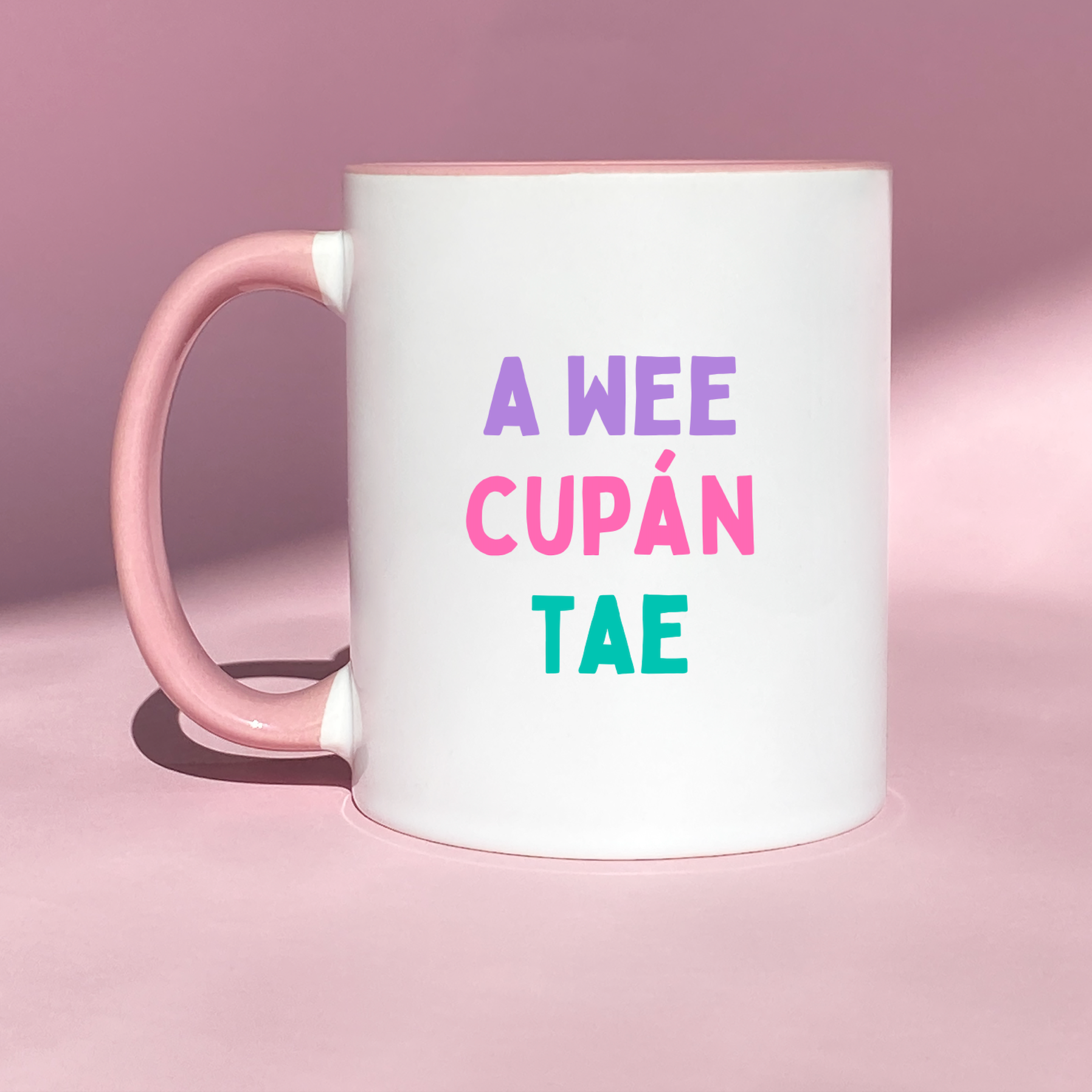 Bright ceramic mug with cheerful, colorful text that reads 'A Wee Cupán Tae,' celebrating Irish tea traditions in a playful design