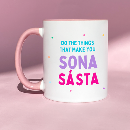 Colorful ceramic mug with the phrase 'Do the Things That Make You Sona Sásta' and vibrant spots, featuring a pink flower on the reverse