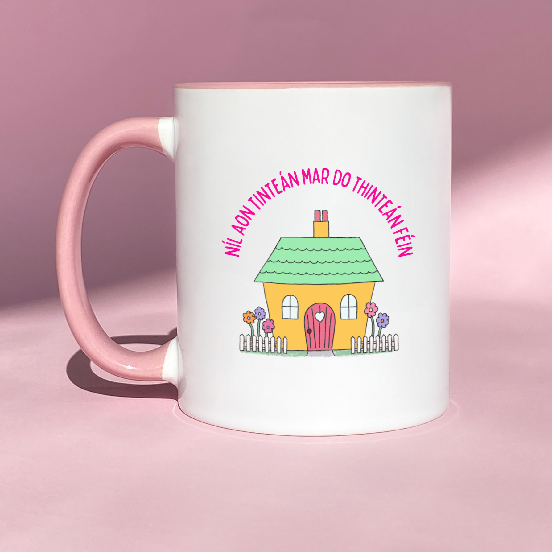 1oz ceramic mug featuring the Irish proverb 'Níl Aon Tinteán Mar Do Thinteán Féin,' with a cute house illustration.